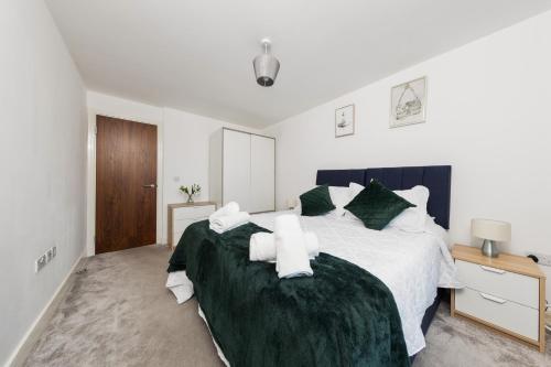 a bedroom with a large bed with green sheets at 40 Percent OFF - Long Stays - City Centre - Close to Bullring - Suitable for Business, Families, Relocations and Leisure - EastGate l Free WiFi I in Birmingham