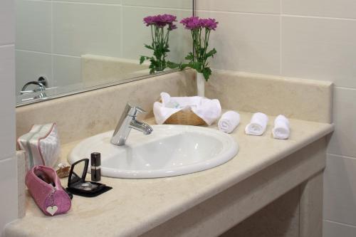 a bathroom counter with a sink and a mirror at Margarona Royal Hotel in Preveza
