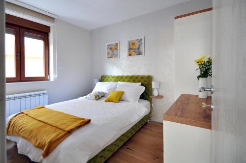 a bedroom with a bed with a green headboard at Apartman Antic 1 in Vrnjačka Banja