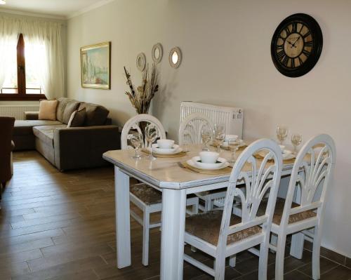 mesa de comedor blanca con sillas y reloj en Kassiani House, en Theológos