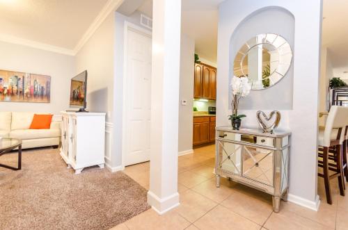 a living room with a couch and a table with a mirror at Spacious Condo in Vista Cay Resort LUXURY AWAITS in Orlando