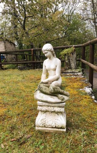 a statue of a girl sitting on a rock at Angolo di Paradiso B&B in Grizzana