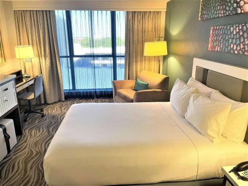 a hotel room with a large bed and a chair at Wyndham Lake Buena Vista – Disney Springs® Area in Orlando
