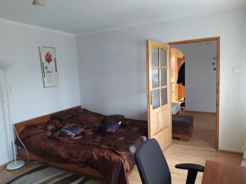 a bedroom with a bed and a chair and a mirror at Apartament z Widokiem na Śnieżkę in Jelenia Góra