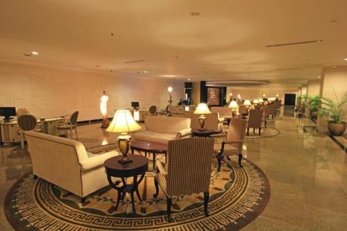 a lobby with chairs and tables in a building at Harmoni One Convention Hotel and Service Apartments in Batam Center