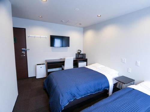 Un pat sau paturi într-o cameră la HOTEL LiVEMAX Yokohama Kannai Ekimae
