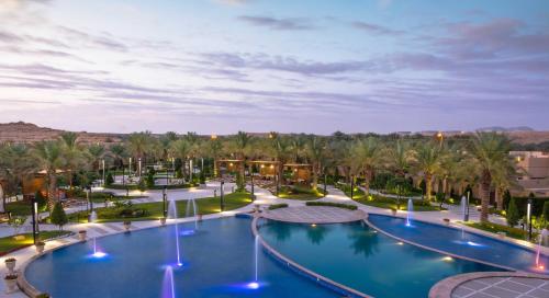 widok na basen w ośrodku z palmami w obiekcie Dorat Najd Resort w Rijadzie