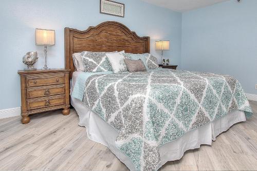 a bedroom with a bed and a night stand with two lamps at Reef Club 107 in Clearwater Beach
