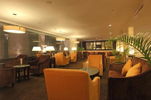 a hotel lobby with couches and tables and chairs at Harmoni One Convention Hotel and Service Apartments in Batam Center