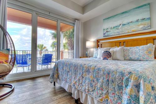 - une chambre avec un lit et un balcon avec des chaises bleues dans l'établissement Harborview Grande 207, à Clearwater Beach