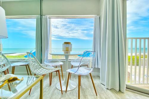 a room with a table and chairs and a view of the ocean at Belleair Beach Club 112 in Clearwater Beach