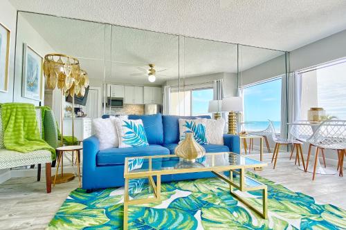 a living room with a blue couch and a table at Belleair Beach Club 112 in Clearwater Beach