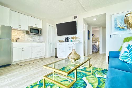 a living room with a blue couch and a glass table at Belleair Beach Club 112 in Clearwater Beach