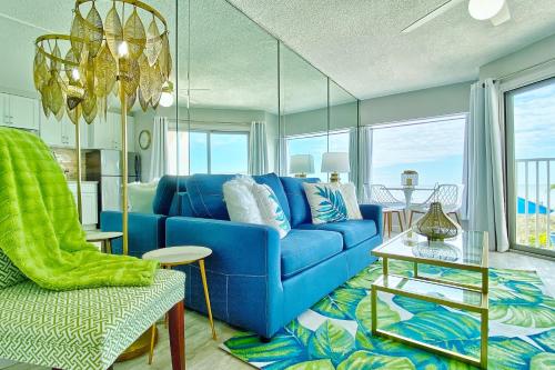 a living room with a blue couch and a table at Belleair Beach Club 112 in Clearwater Beach