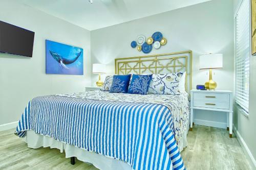 a bedroom with a bed with a blue and white comforter at Belleair Beach Club 112 in Clearwater Beach