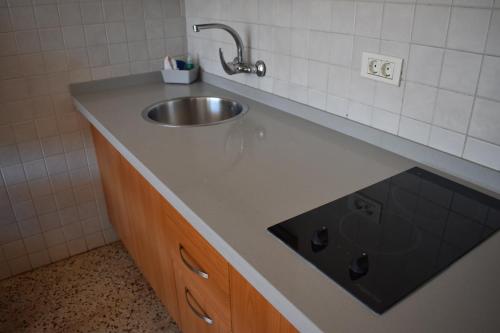 Apartamentos Mayagüez - Adults Only في بورتو ريكو: منضدة الحمام مع وجود مغسلة في الحمام