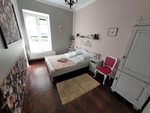 a bedroom with a bed and a red chair at Old Town Apartment in Gdańsk