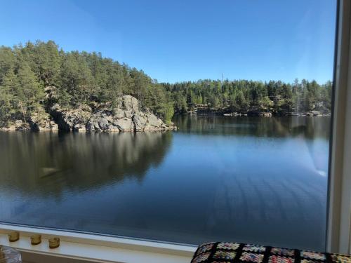a view of a lake seen through a window at Lyseren waterfront cabin in Omberg
