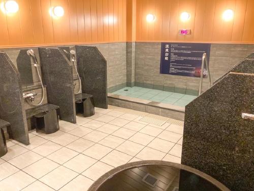 baño con 2 urinarios y lavamanos en HOTEL LiVEMAX PREMIUM Nagoya Marunouchi en Nagoya