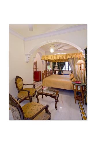 ジャイプールにあるMadhuban - A Heritage Homeのベッドルーム(キングサイズベッド1台、椅子付)