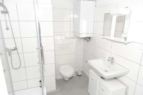 a white bathroom with a toilet and a sink at Othman Appartements Anderter Straße 55g in Hannover