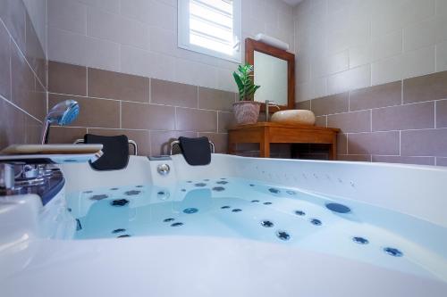 a bathroom with a large tub in a room at Le Be-Mahot - Hell Bourg in Salazie