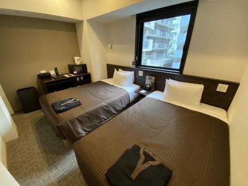 Postel nebo postele na pokoji v ubytování HOTEL LiVEMAX PREMIUM Nagoya Marunouchi