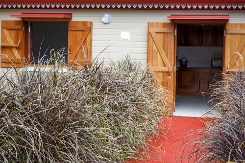 a house with a red door and some grass at Le Be-Mahot - Hell Bourg in Salazie