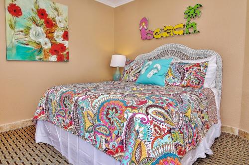 1 dormitorio con 1 cama con colcha colorida en Belleair Beach Club 315 en Clearwater Beach