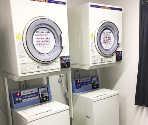 two machines in a laundry room with a machine at HOTEL LiVEMAX Chiba Minato Eki-mae in Chiba