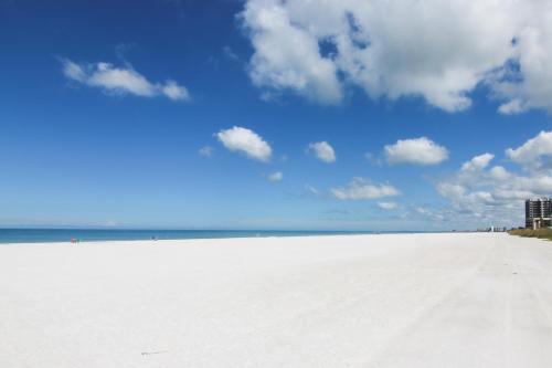 a white sandy beach with a blue sky and clouds at Belleair Beach Club 315 in Clearwater Beach