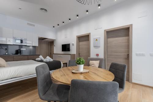 Travel Habitat Benimaclet Vista Hermosa Suites في فالنسيا: غرفة مع طاولة وكراسي وسرير