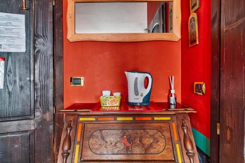 a small table in a room with a red wall at Hotel Portacavana in Trieste