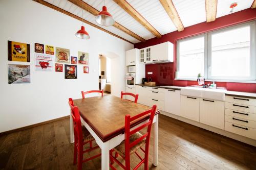 une cuisine avec une table en bois et des chaises rouges dans l'établissement Historic Center - Top location - Thoughtful Host, à Colmar