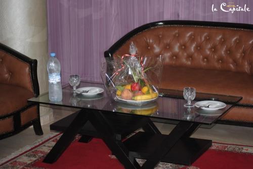 Hotel La Capitale في الرباط: طاولة مع وعاء من الفواكه على أريكة