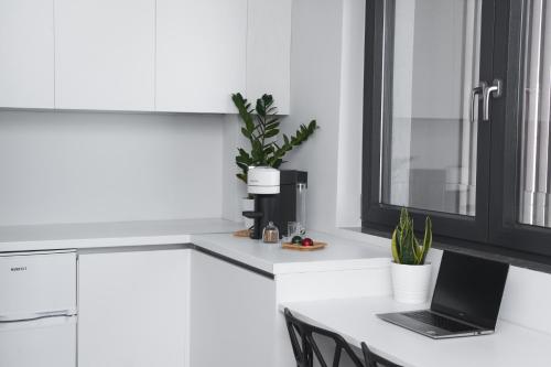 a white kitchen with a laptop on a counter at 7Rizes Luxury Living in Heraklio Town