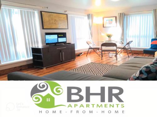 a living room with a couch and a tv and a table at Perfect Central City Location - Parking - 4 Beds - 2 Bedrooms in Belfast
