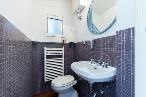 a bathroom with a sink and a toilet and a mirror at Milan Retreats in Milan