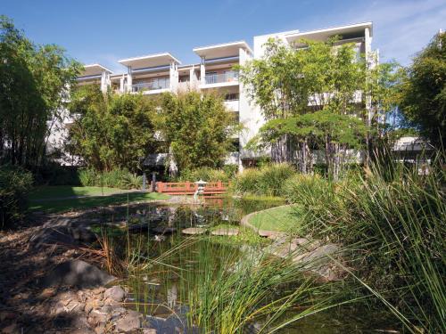 a building with a pond in front of a building at Oaks Brisbane Mews Suites in Brisbane