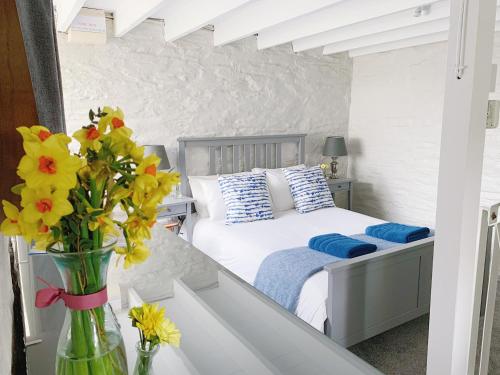 a bedroom with a bed with yellow flowers in a vase at The Laurels Holiday Park & Cottages nr Padstow and Wadebridge in Wadebridge
