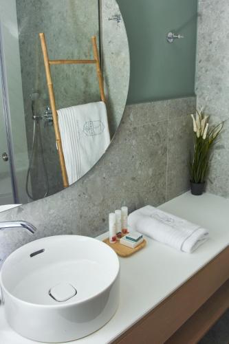 a bathroom with a white sink and a mirror at 7Rizes Luxury Living in Heraklio Town