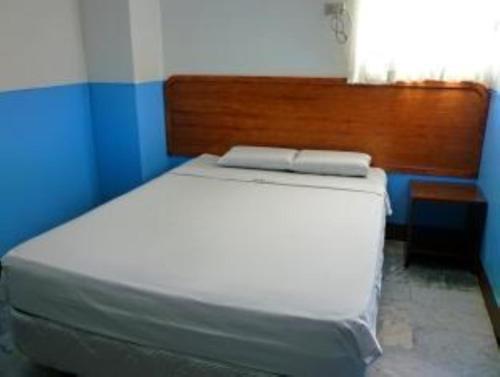 Bett in einem Zimmer mit einer blau-weißen Wand in der Unterkunft GV Hotel - Davao in Davao City