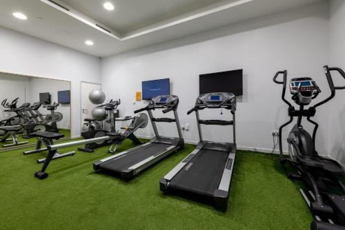 a gym with tread machines and green carpet at For Students Only Middle Street in Portsmouth in Portsmouth
