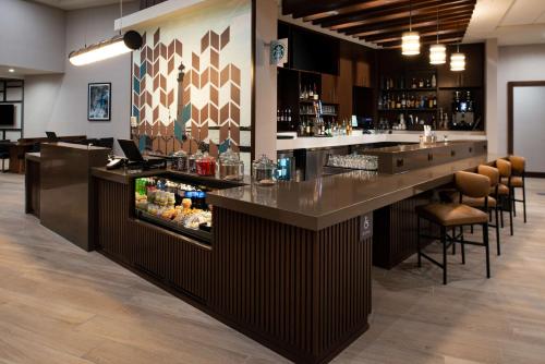 a bar in a restaurant with a counter and stools at Hyatt Place Dallas/Rockwall in Rockwall