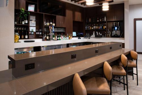 a bar with a counter with stools in a room at Hyatt Place Dallas/Rockwall in Rockwall