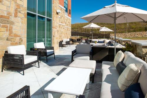 a patio with white furniture and an umbrella at Hyatt Place Dallas/Rockwall in Rockwall