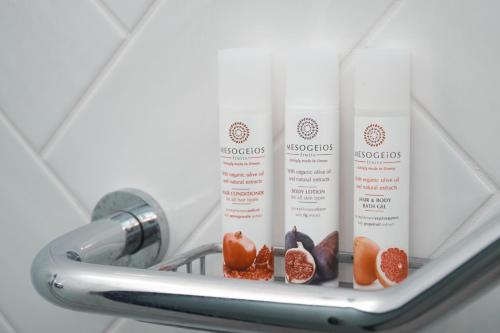 a shelf with two white shampoo bottles and fruit at 7Rizes Luxury Living in Heraklio Town