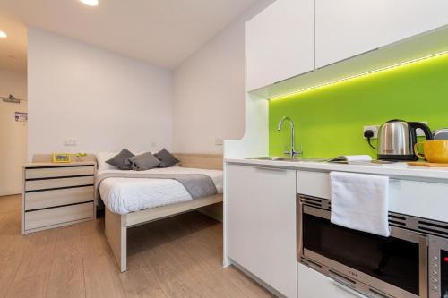 a room with a bed and a kitchen with a sink at For Students Only Middle Street in Portsmouth in Portsmouth