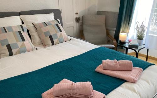 ein Bett mit zwei Handtüchern darüber in der Unterkunft Centre Vaison-la-Romaine, Appartement T2 in Vaison-la-Romaine