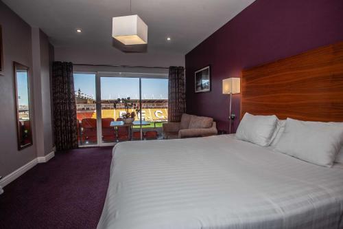 a hotel room with a large bed and a balcony at Blackpool Football Club Stadium Hotel, a member of Radisson Individuals in Blackpool